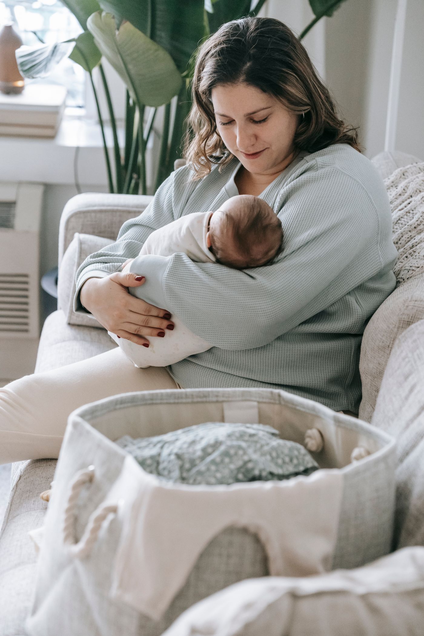 A parent holding their sleeping newborn at home